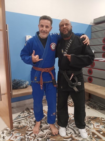 Two United BJJ AZ members in gis, one a brown belt, after training.